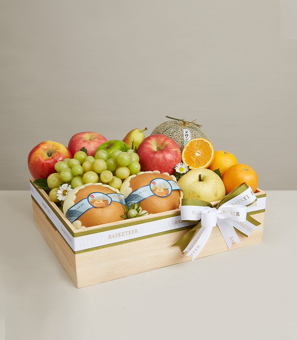 Gift boxes filled with various types of premium grade fresh fruits such as red, green apples, oranges, yellow Chinese pears and more, decorated with green and white ribbon bows and the words 