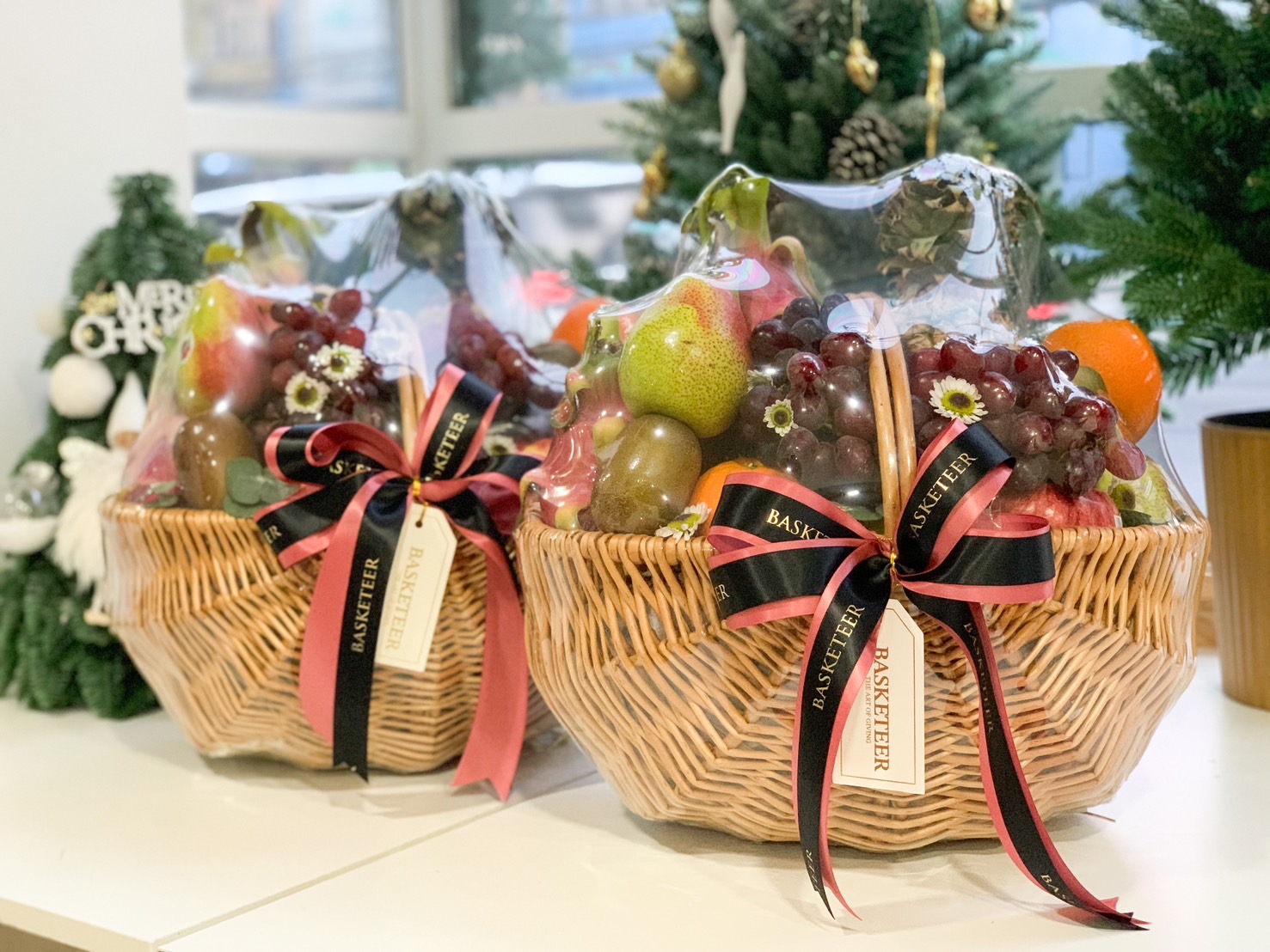 Premium fresh fruit gift basket with apples, pears, grapes, and festive decorations by Basketeer.