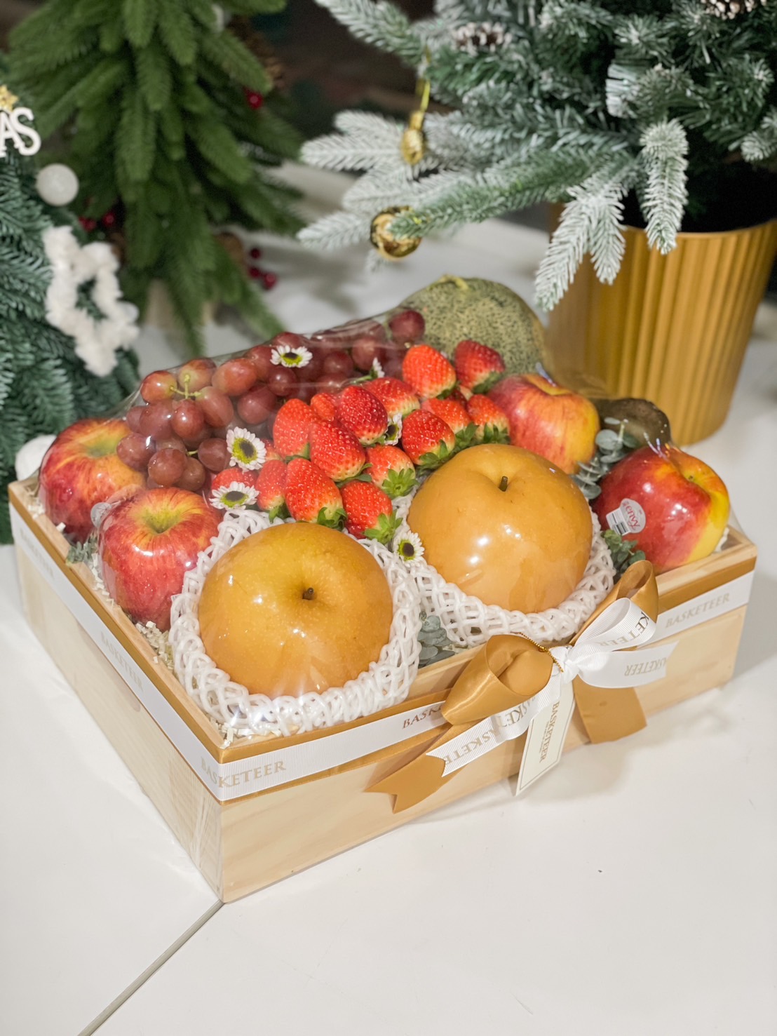 Wooden gift box with Korean pears, strawberries, apples, grapes, and a melon by Basketeer.