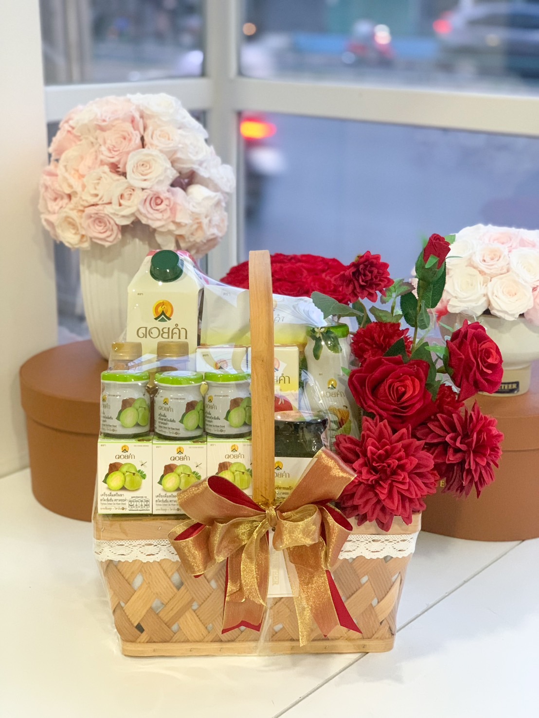 Doi Kham health gift basket with red floral accents and golden ribbon.