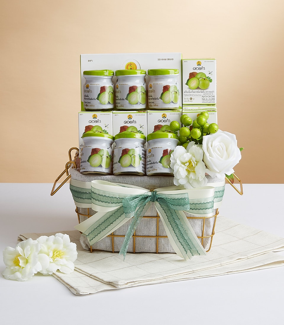 A luxurious gift basket exuding elegance, adorned with sumptuous green and white ribbons and the distinguished Basketeer logo. The Basketeer basket overflows with meticulously arranged jars of exquisite green grape juice, each jar a testament to refined taste. Enveloped by lush clusters of green grapes and pristine white flowers, this scene is a harmonious display of sophistication set against an inviting beige backdrop.