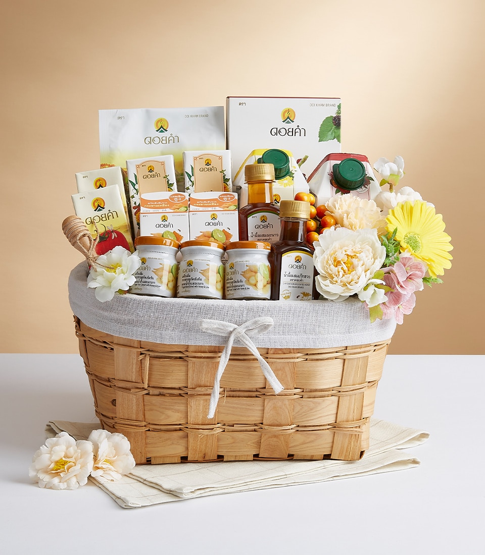 An exquisite wicker basket overflowing with a curated selection of premium wellness and skincare treasures from Basketeer. The ensemble includes elegantly designed bottles, luxurious jars, and beautifully packaged packets and boxes, each meticulously placed to create a harmonious presentation. This opulent basket, adorned with vibrant artificial flowers and lined with sumptuous light gray cloth, is completed by the presence of a tasteful ribbon bearing the distinguished Basketeer logo. A true reflection of refined indulgence and sophisticated self-care.