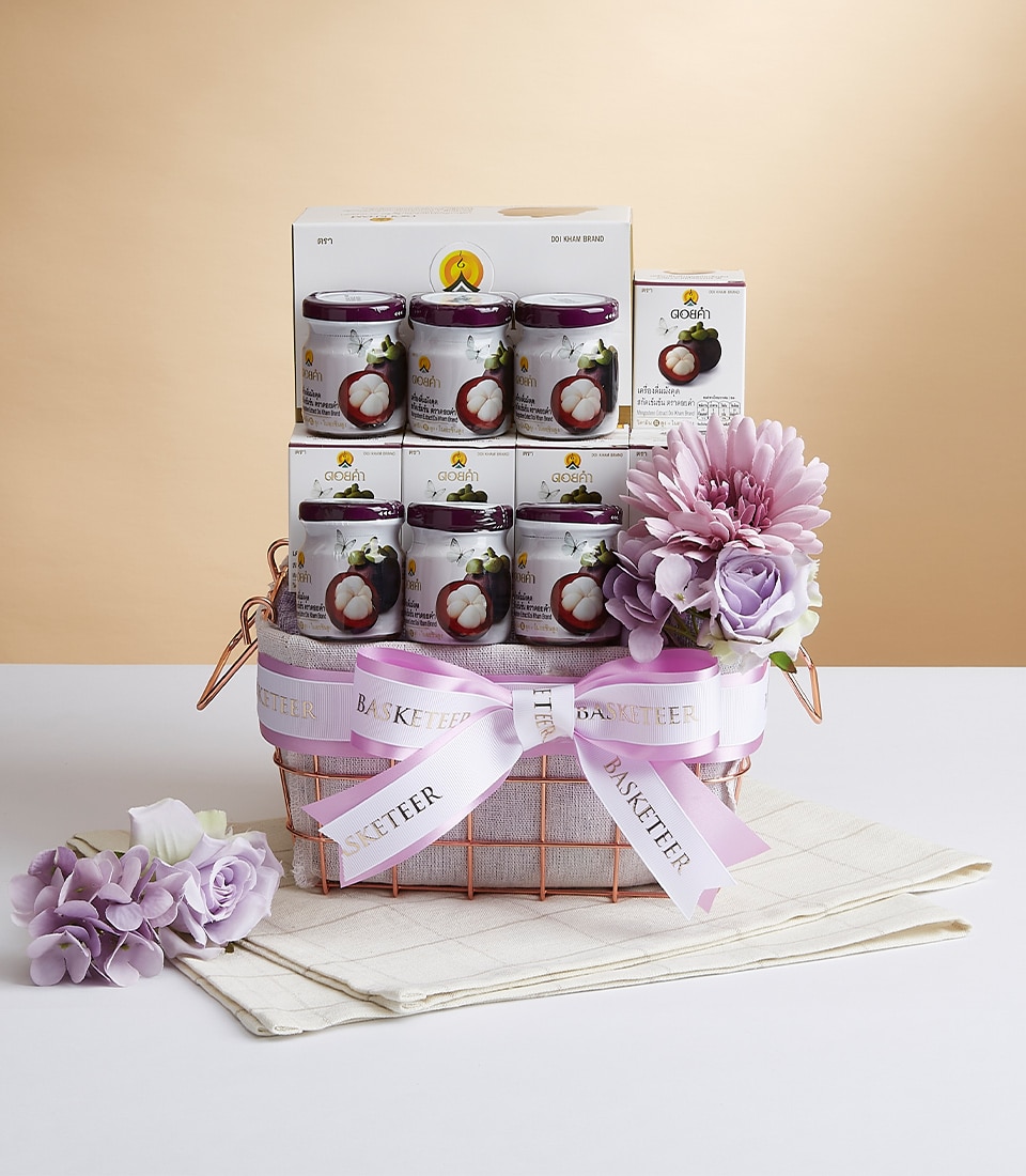 A luxurious gift basket elegantly accented with a pink ribbon reading 