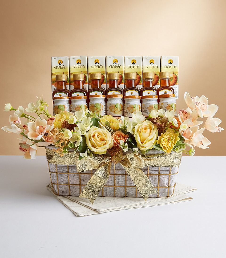 ตะกร้าตกแต่งที่ประดิษฐ์อย่างหรูหราประดับด้วยโบว์อันหรูหรา จัดแสดงน้ำผึ้งอันงดงามจำนวน 6 ขวด การจัดดอกไม้ได้รับการปรับปรุงอย่างงดงามด้วยดอกกุหลาบสีเหลืองประดิษฐ์และดอกไม้สีพีช โดยมีฉากหลังเป็นสีกลางที่ดูหรูหรา ริบบิ้นที่มีโลโก้ Basketeer อันโดดเด่นช่วยเชื่อมโยงฉากต่างๆ เข้าด้วยกันอย่างหรูหรา เพิ่มความหรูหราและความประณีตเป็นพิเศษ