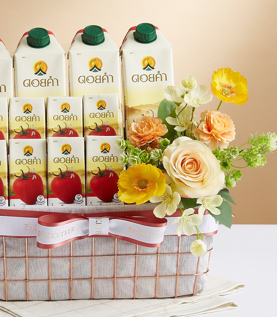 A luxurious gift basket by Basketeer, elegantly arranged with ten cartons of premium juice. Adorned with a breathtaking bouquet of delicate roses and carnations in shades of yellow, white, and soft orange, this exquisite ensemble exudes opulence. The beige checkered fabric design provides a sophisticated backdrop, while a charming pink ribbon adds a touch of refined grace. The iconic Basketeer logo is subtly showcased on the ribbon and gift box, ensuring that each detail epitomizes fine craftsmanship and luxury.