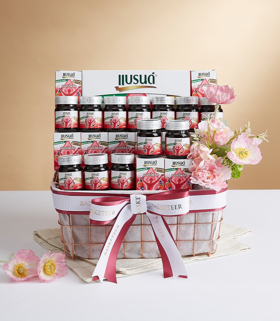 A luxurious decorative basket featuring an exquisite selection of Illusia Bird's Nest beverage bottles, meticulously arranged to captivate the senses. The presentation is elevated with delicate pink and white flowers, gracefully entwined with elegant white and maroon ribbons. A sophisticated Basketeer-branded ribbon adds a touch of prestige, highlighting the premium nature of this offering. Set against a light beige backdrop, the display exudes an air of refined opulence and inviting charm.