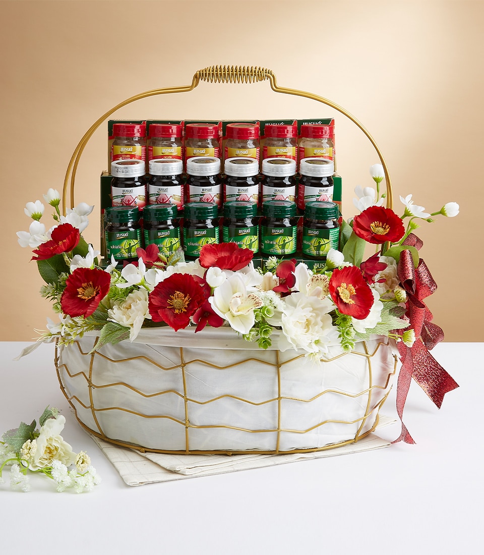 กระเช้าของขวัญสุดหรูที่สร้างสรรค์อย่างประณีตโดย Basketeer เต็มไปด้วยขวดใส่เครื่องเทศและสมุนไพรระดับพรีเมี่ยม การจัดวางที่หรูหราได้รับการประดับประดาอย่างสวยงามด้วยดอกไม้สีแดงสดและสีขาวบริสุทธิ์ ช่วยเพิ่มเสน่ห์ ตะกร้าอันประณีตนี้หุ้มด้วยโครงลวดสีทองหรูหรา โดยมีพื้นหลังสีเบจอ่อน ๆ สื่อถึงความอบอุ่นและความหรูหรา ริบบิ้นสีแดงเข้มผูกโบว์ทางด้านขวาอย่างสวยงาม แสดงให้เห็นโลโก้ Basketeer ที่โดดเด่นอย่างประณีต สื่อถึงความหรูหราและรสนิยมอันประณีต