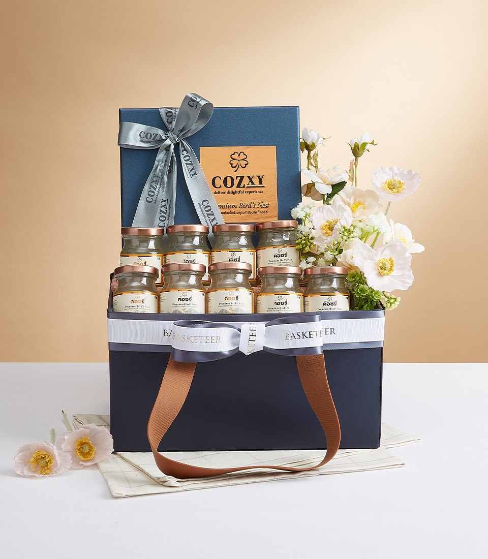 An opulent gift basket showcasing an exquisite selection of honey jars, a luxurious blue binder elegantly tied with a silver ribbon and adorned with the 