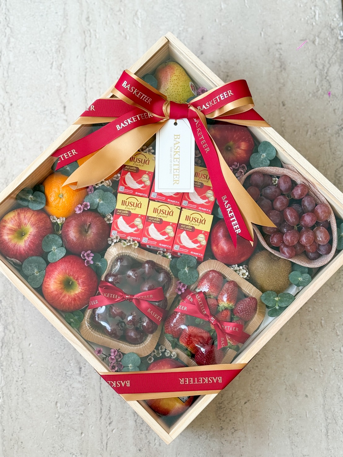 Luxurious Fresh Fruit Gift Box with crisp apples, grapes, kiwi fruit, strawberries, PNSU jelly, elegant greenery and Basketeer ribbons.