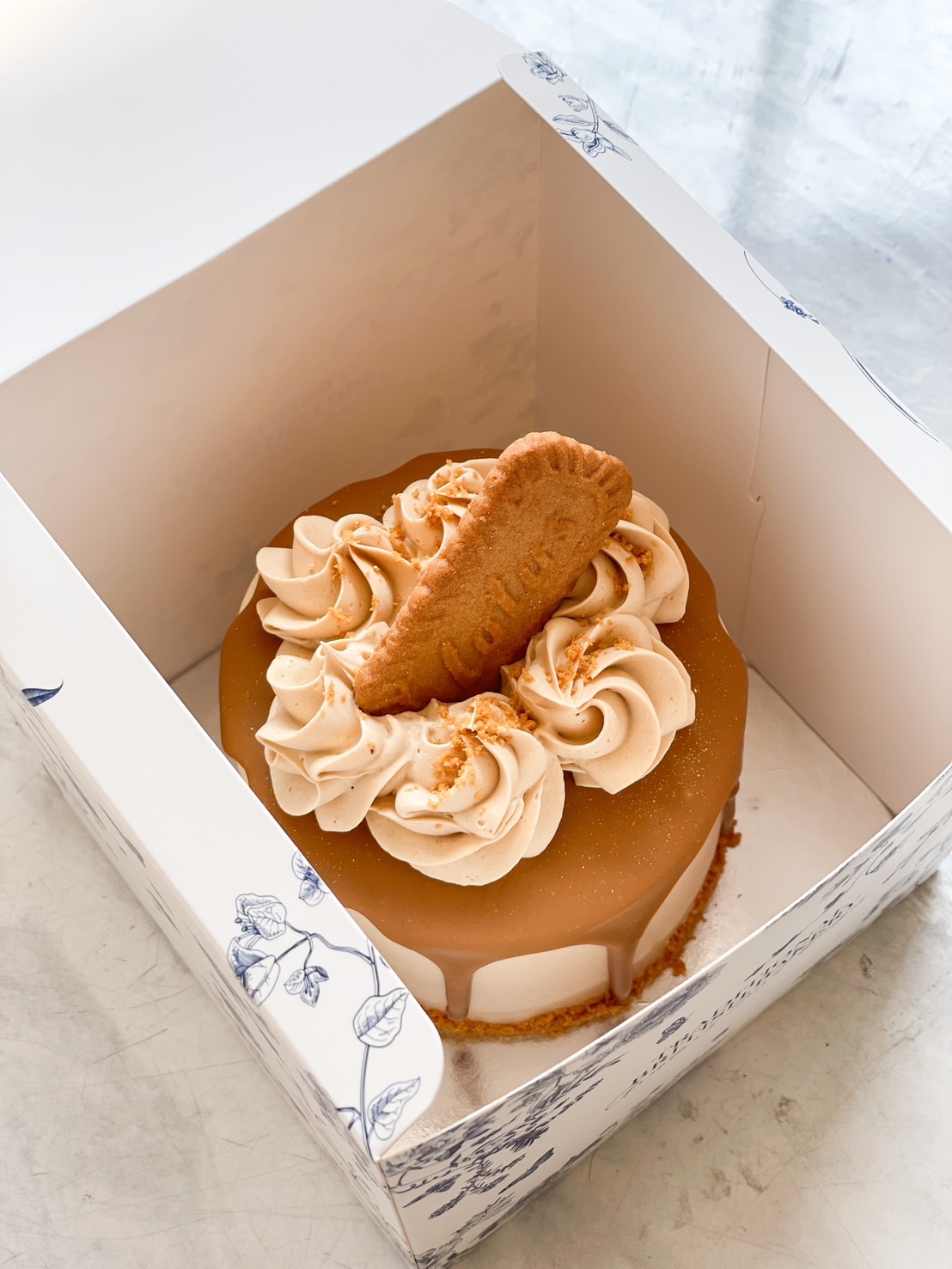 A Lotus Biscoff cake with a smooth caramel glaze, fluffy buttercream swirls, and a crunchy Lotus biscuit topping. A delicious treat for any occasion.