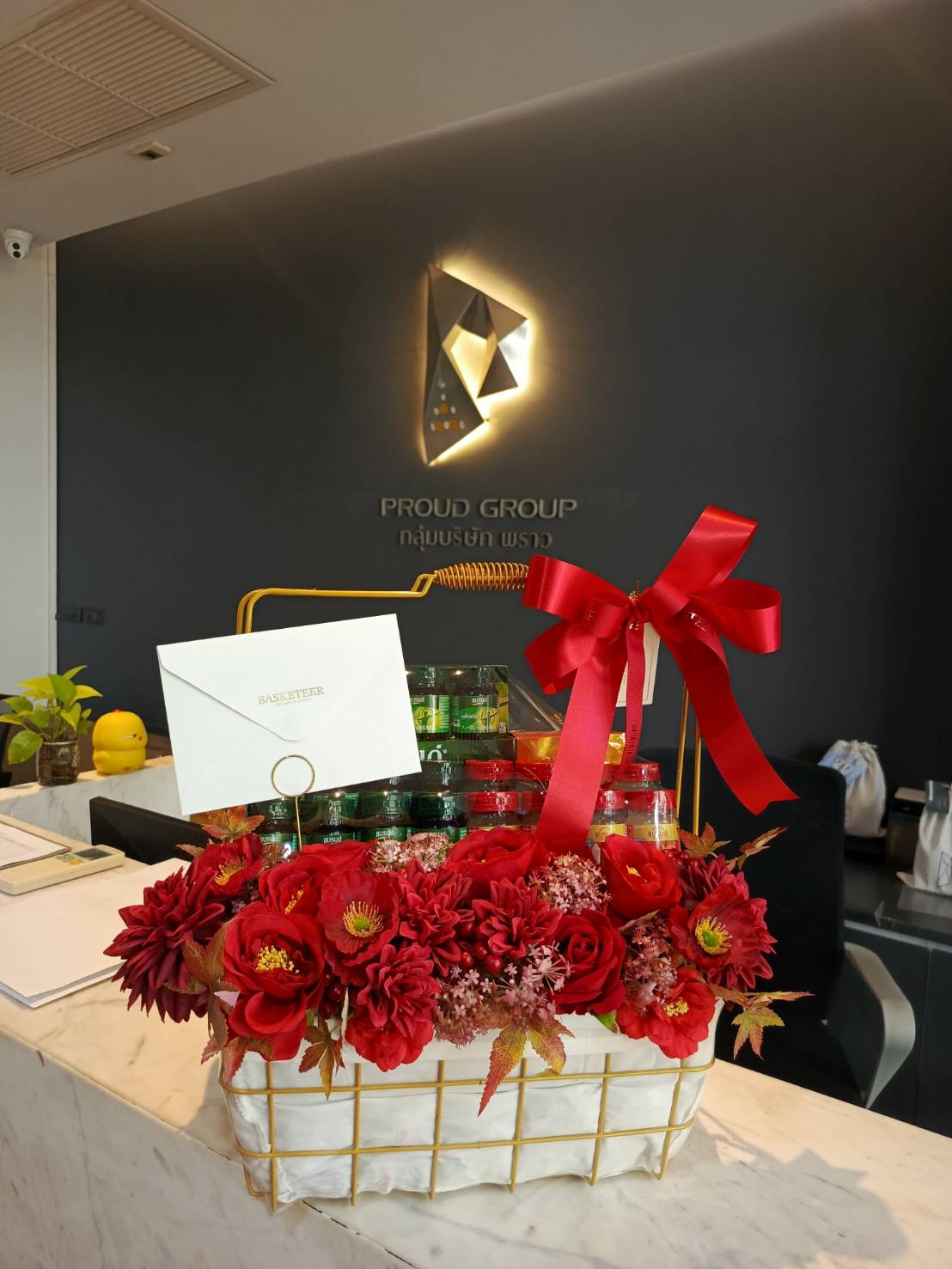 A luxurious bird’s nest gift basket adorned with vibrant red flowers and gold accents, featuring high-quality bird’s nest bottles, wrapped with an elegant red ribbon and a personalized card.