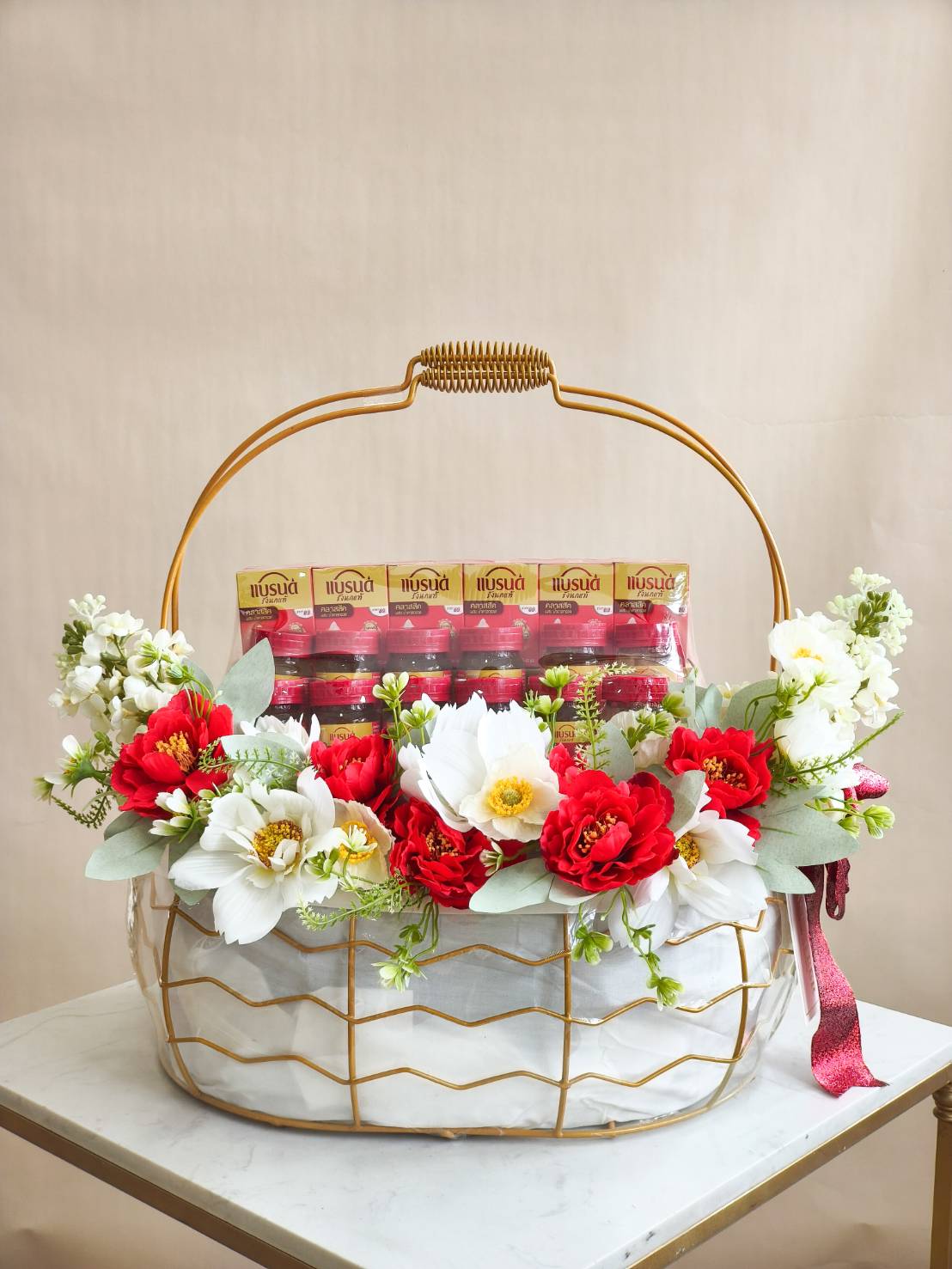 Luxury bird’s nest gift basket with premium Brand’s bird’s nest bottles, decorated with red and white flowers, arranged in a gold wire basket.
