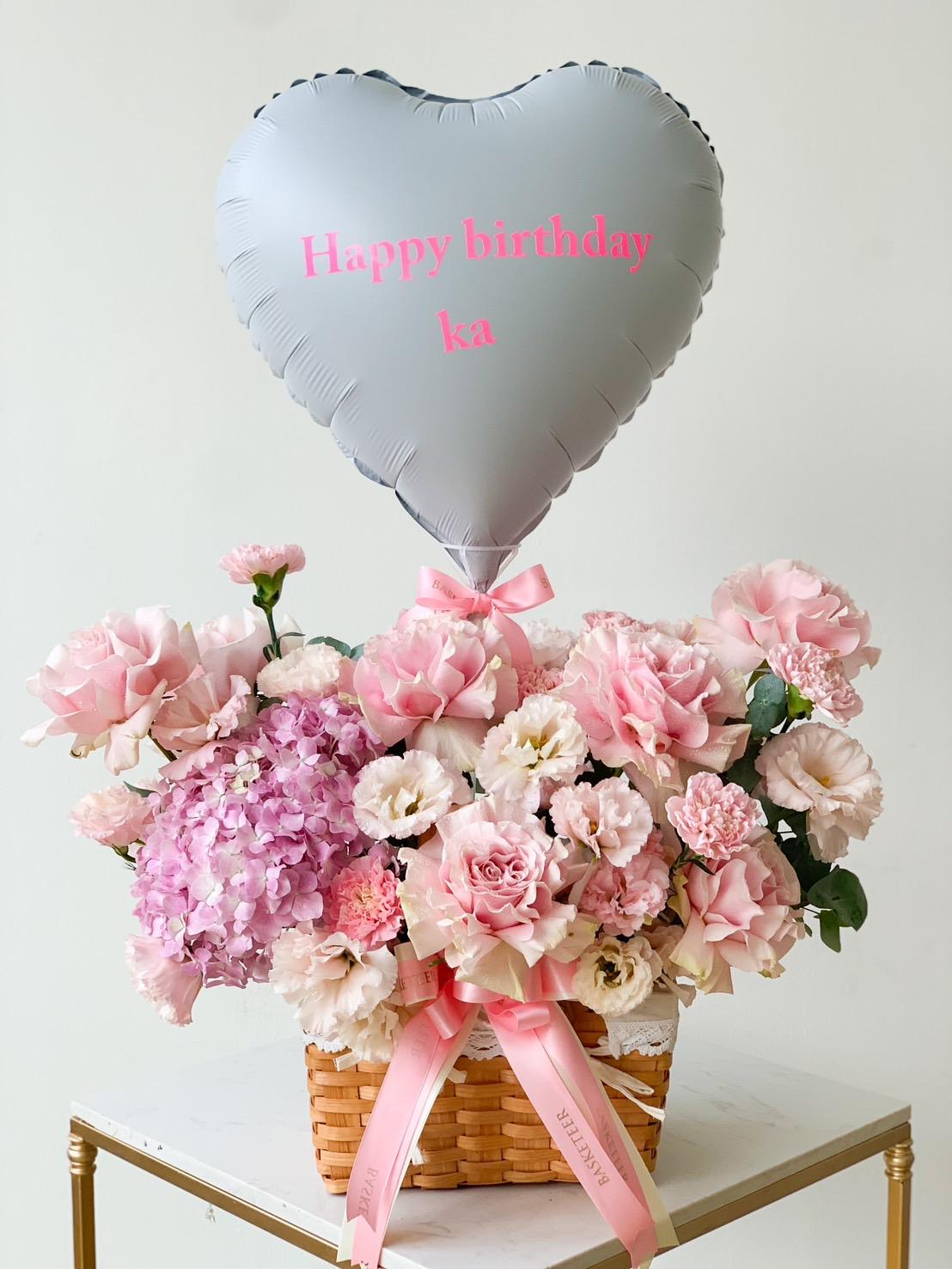 A heart-shaped silver balloon with 