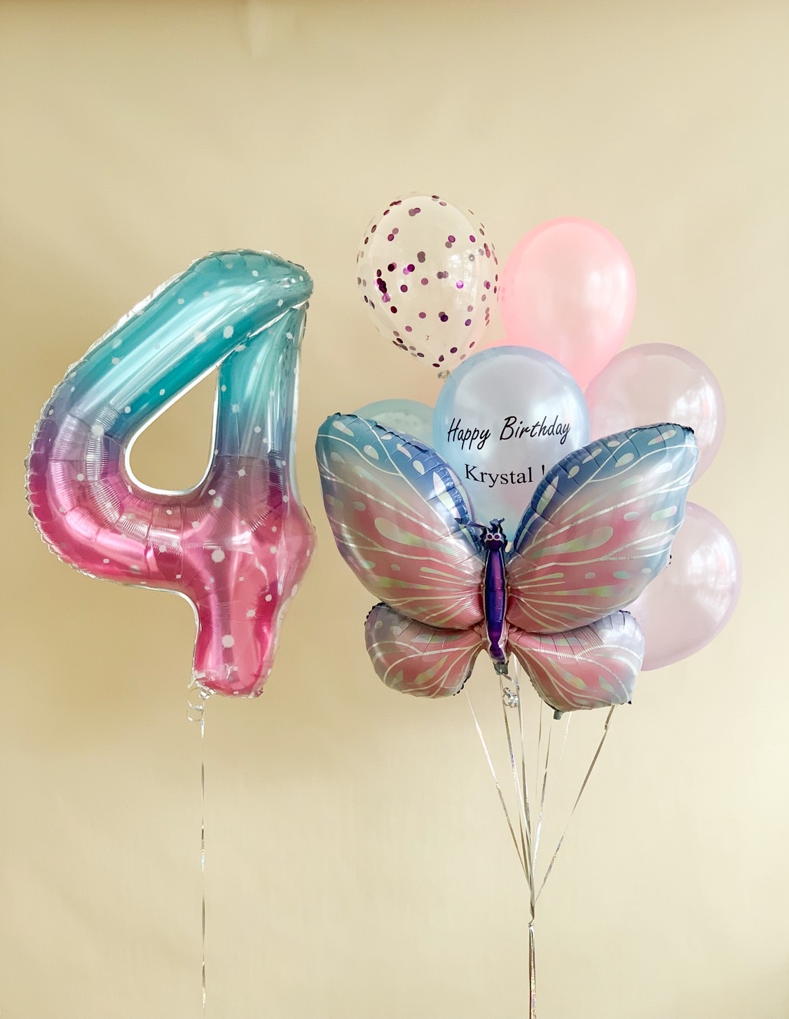 Pastel number 4 balloon with butterfly foil balloon and pink birthday balloons bouquet for girls’ birthday celebrations.