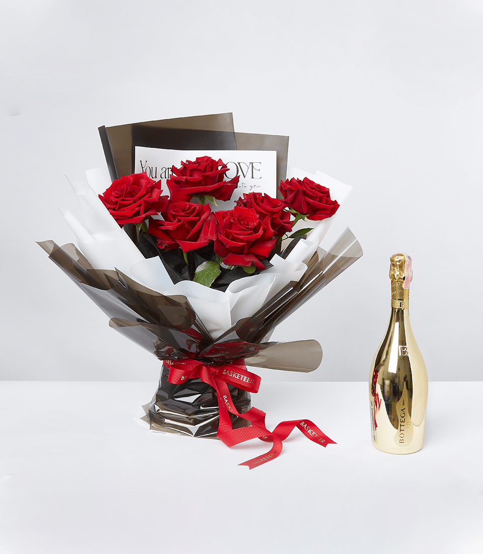 A stunning bouquet of red roses paired with a premium beverage in a golden bottle, elegantly arranged for romantic occasions.