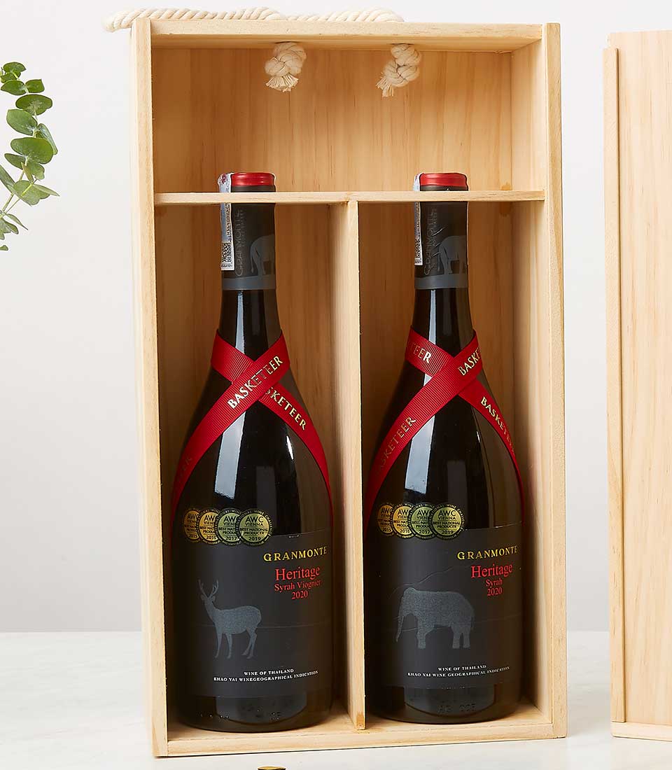 A sumptuous wooden box cradles two exquisite bottles of Granmonte Heritage Syrah 2008 wine, each elegantly adorned with a rich red ribbon inscribed with 