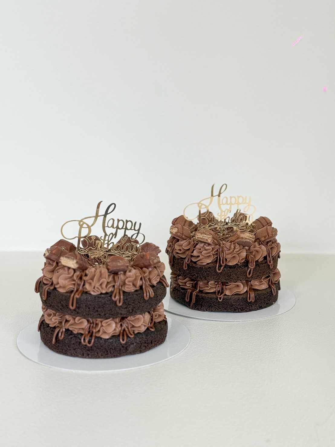 Double layer chocolate birthday cake with rich frosting, drip design, and chocolate toppings, finished with Happy Birthday topper