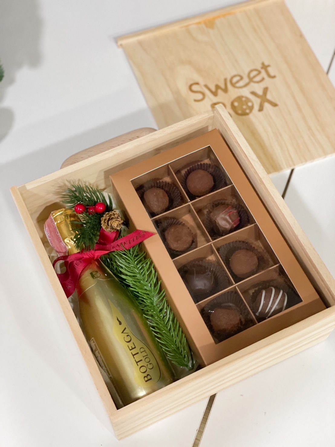Wooden gift box with premium chocolates and festive holiday decorations by Basketeer.