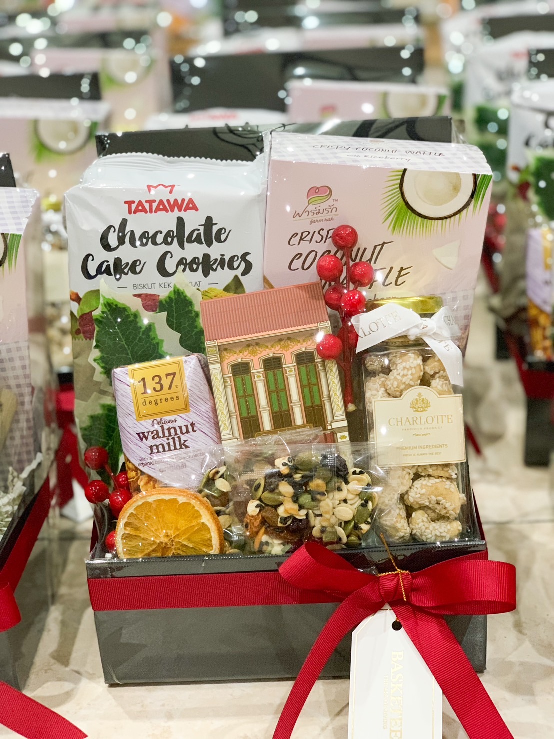 Gift set with crispy coconut waffles, chocolate cake cookies, mixed nuts, and festive decorations by Basketeer.