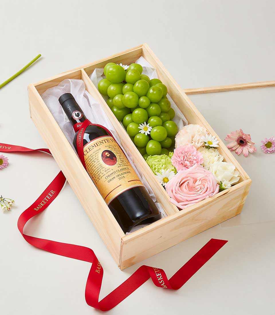A lavish wooden gift box adorned with elegant red ribbons features a prestigious bottle of 