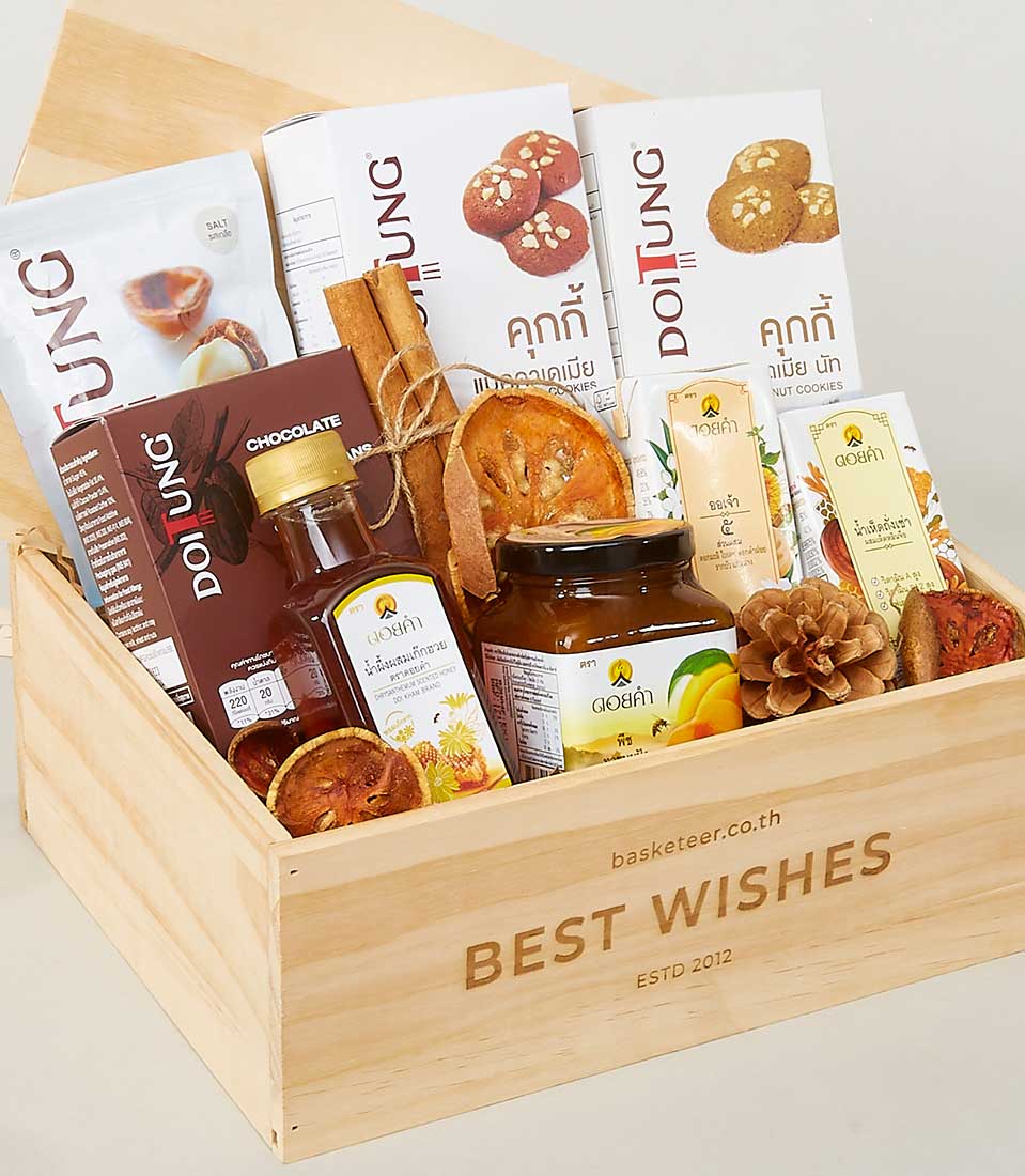 A luxurious gift box from Basketeer, elegantly curated with an assortment of indulgent treats including gourmet cookies, decadent chocolates, a jar of artisanal jam, premium coffee packets, and finely selected dried fruits. The exquisite wooden box is adorned with 