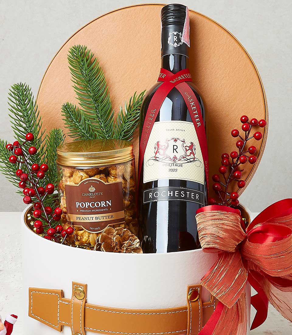 A lavish gift basket by Basketeer, adorned with the brand's signature ribbon, features an exquisite bottle of 