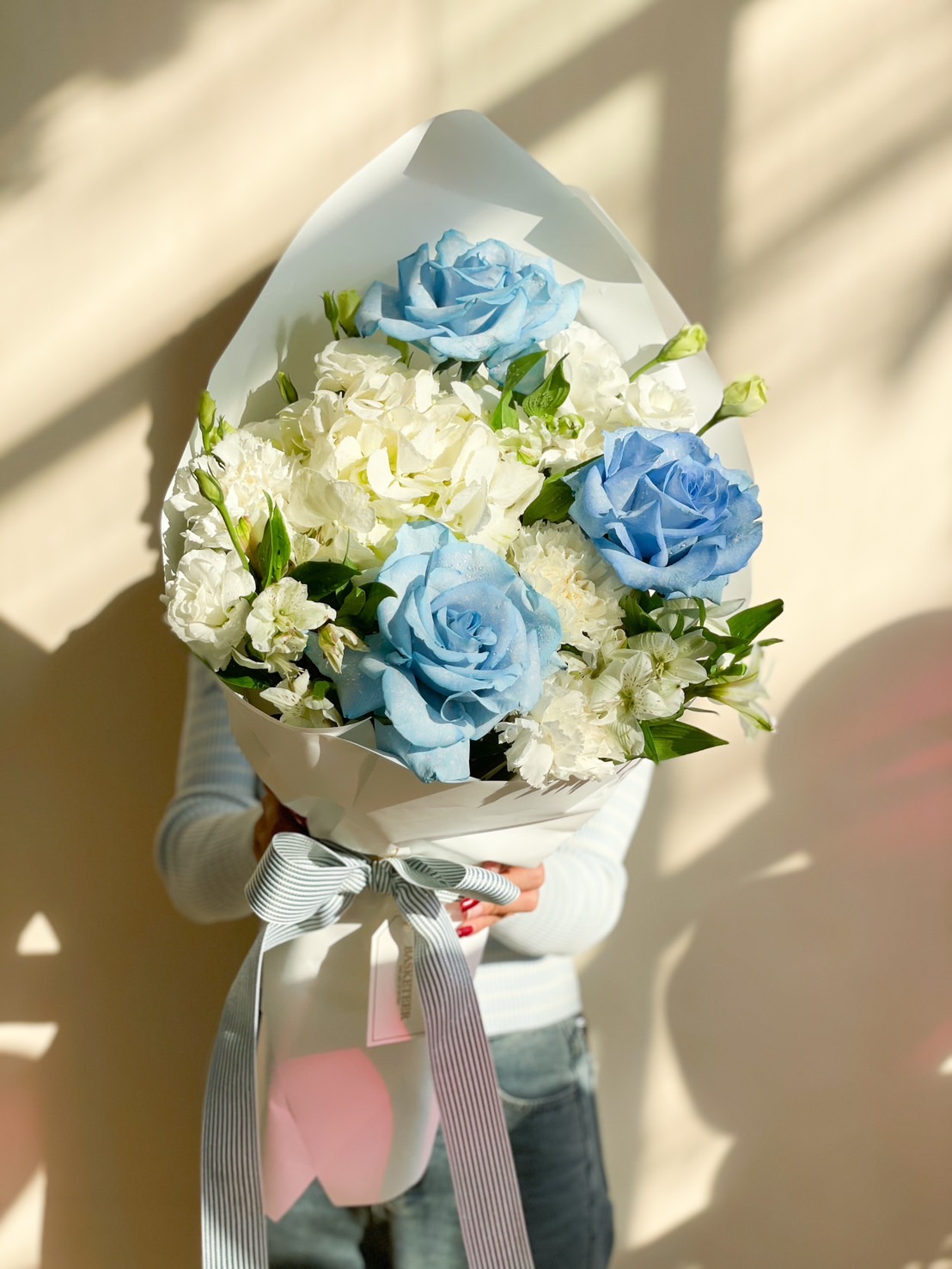A luxurious blue and white bouquet featuring fresh roses and hydrangeas, wrapped beautifully in white paper, perfect for romantic gestures, birthdays, and celebrations.
