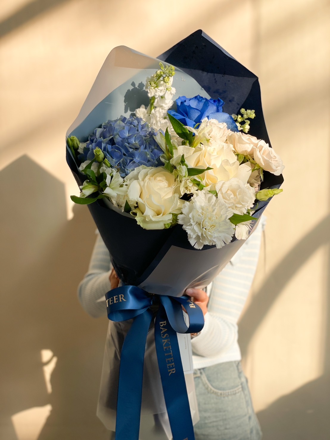 A stunning blue and white floral bouquet with hydrangeas, roses, and premium blooms, elegantly wrapped with a navy ribbon—ideal for romantic gifts, weddings, and anniversaries.