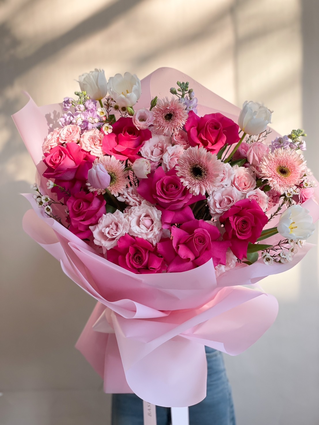 A stunning pink and white floral bouquet with vibrant roses, tulips, and premium flowers, elegantly wrapped—ideal for romantic gifts, birthdays, and special occasions.