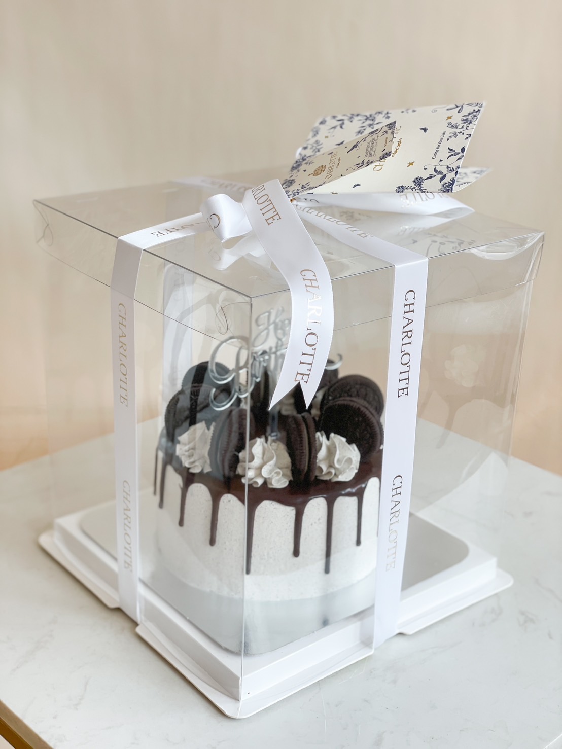 A delicious cookies & cream drip cake with Oreo cookies, chocolate ganache, and fresh whipped cream, elegantly packaged in a luxury gift box.