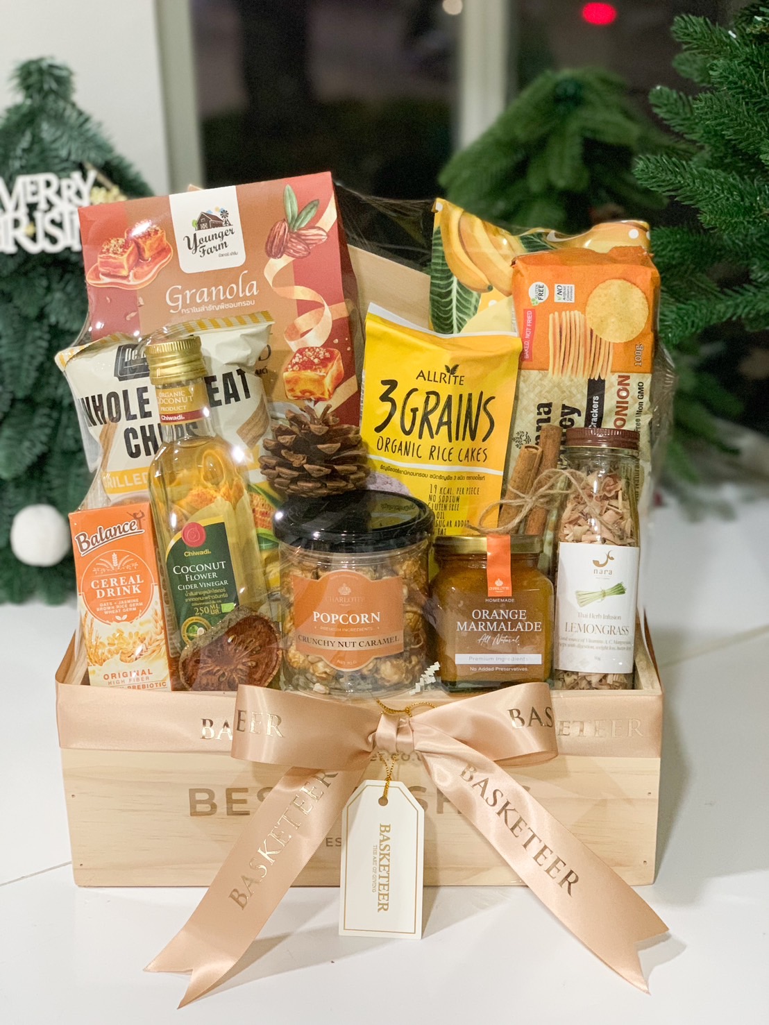 Premium wooden hamper filled with granola, rice cakes, caramel popcorn, marmalade, and healthy snacks, adorned with a peach Basketeer ribbon.