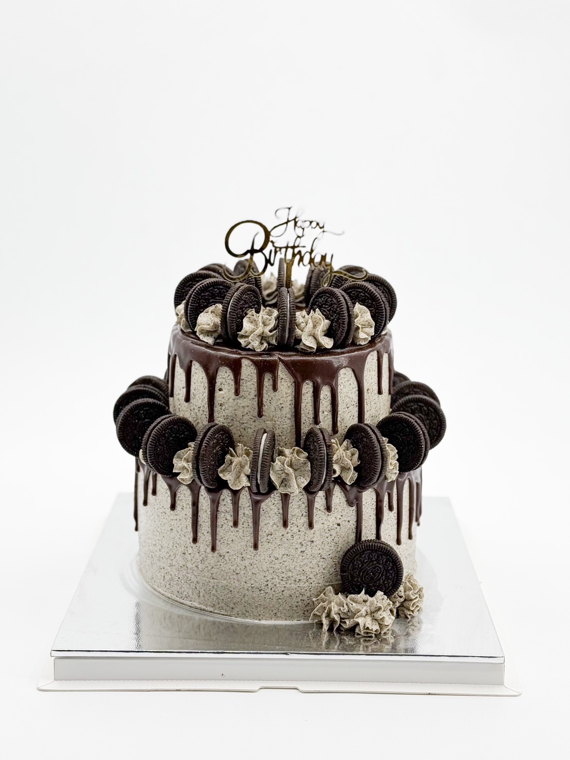 A two-tier Oreo cookies and cream cake with rich chocolate ganache drips, topped and decorated with whole Oreos and swirls of cookies & cream frosting.