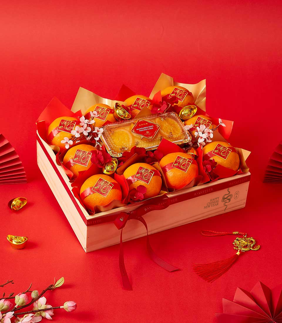 Mandarin orange and prosperity cake gift set in a wooden crate, decorated with red and gold festive accents for Chinese New Year celebrations.