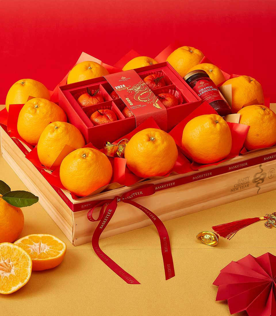 Chinese New Year gift crate with mandarin oranges, festive red packaging, and orange marmalade in a wooden box.