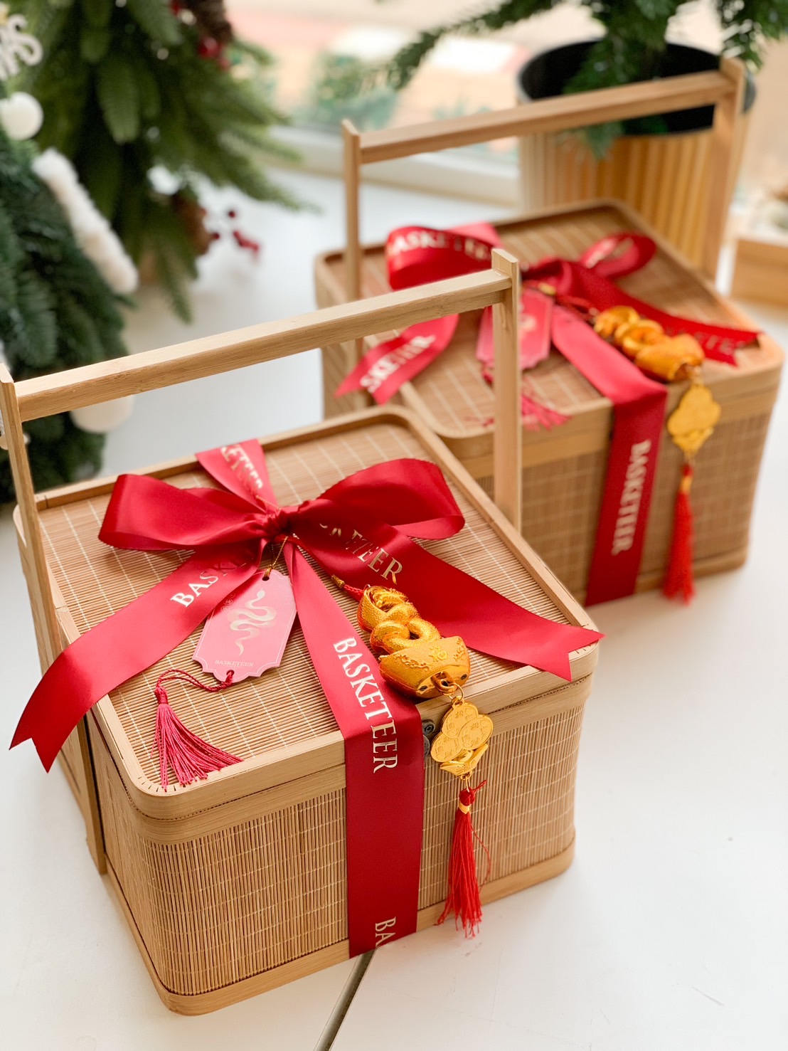 A luxurious gift hamper in a leather-style trunk, featuring Rhanleigh Merlot wine, fresh mandarin oranges, chocolates, cookies, and festive decorations.