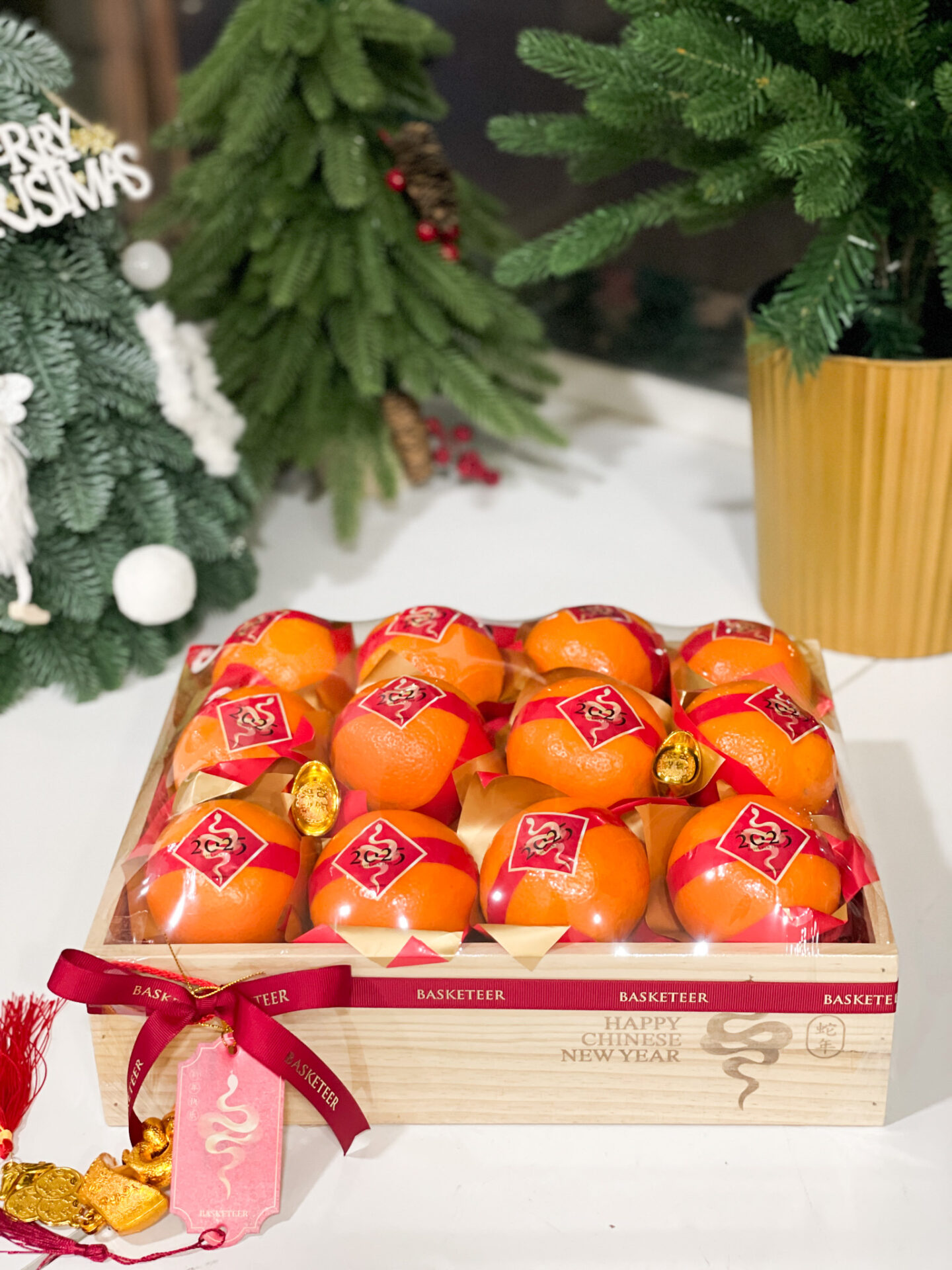Elegant wooden box containing premium mandarin oranges decorated with red and gold ribbons, adorned with festive charms, perfect for Chinese New Year celebrations.