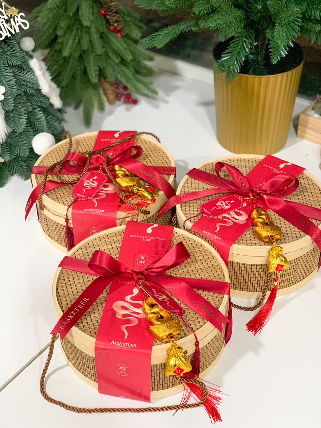 Chinese New Year bamboo gift baskets with red ribbons, festive gold charms, and traditional red packaging by Basketeer.