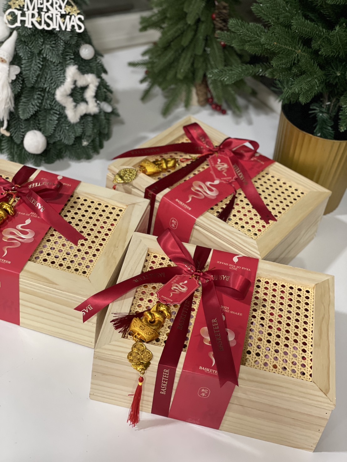 Three A beautifully crafted bamboo box with red ribbon, golden snake charm, and a festive Chinese New Year design.