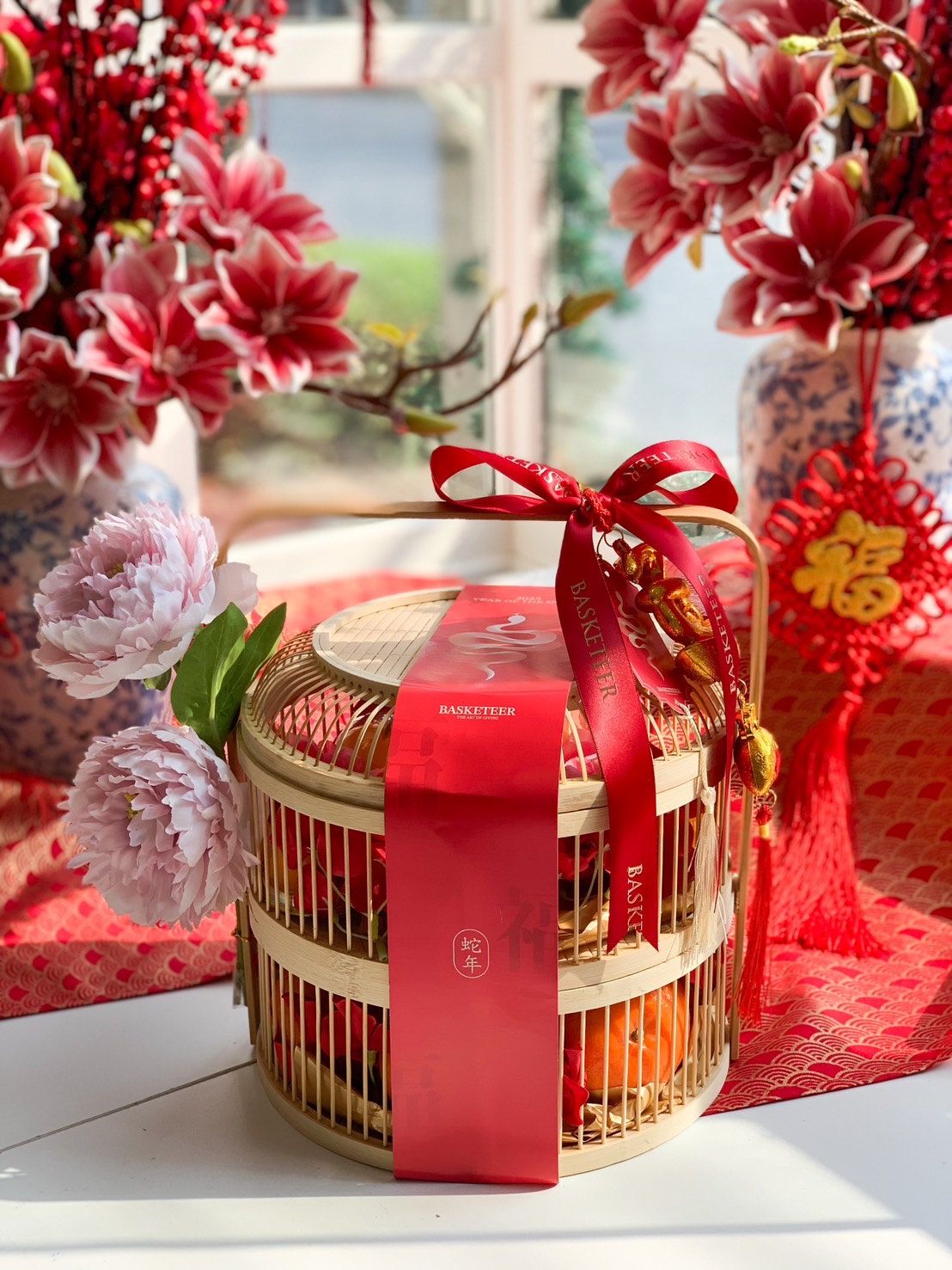 Chinese New Year gift basket with fresh mandarin oranges, presented in a traditional bamboo basket with festive red ribbon and golden accents.