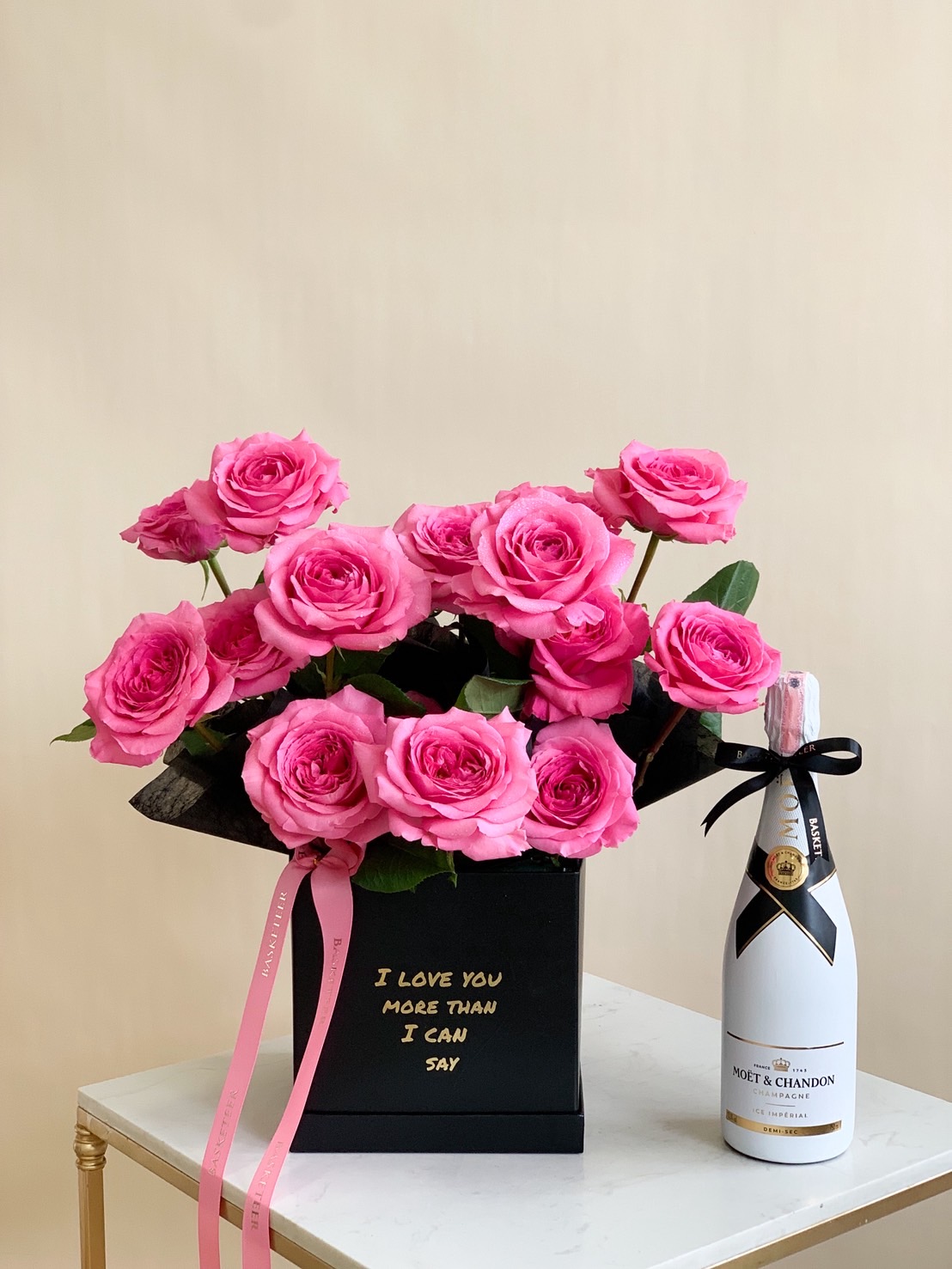Luxury hot pink roses in black box with Moët & Chandon champagne for romantic gifting.