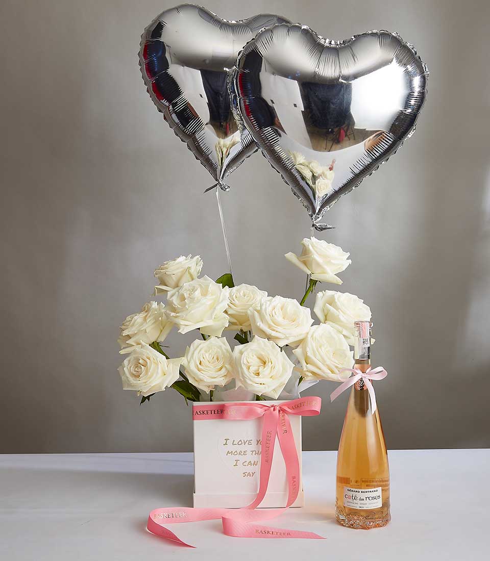 Valentine's Wine With Playa Blanca White Roses and Heart Gray Balloons in the Bag Box with a Pink Bow.