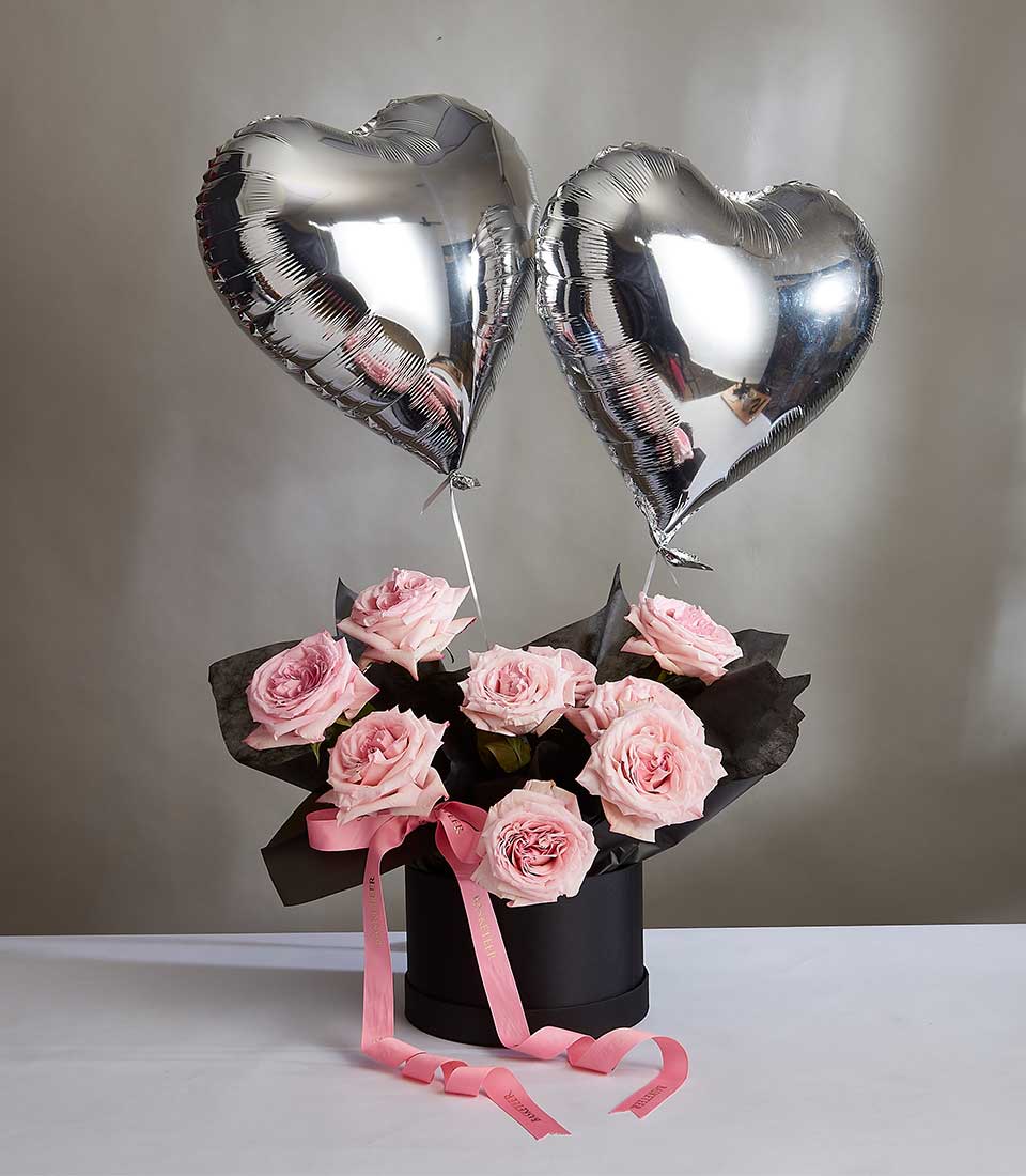 Experience the epitome of elegance with our Pink O'Hara Roses Box nestled in a sleek black box accompanied by charming gray heart balloons. Perfect for birthdays, Valentine's Day, or any special occasion. Delight your loved ones with this sophisticated floral arrangement. Order now!