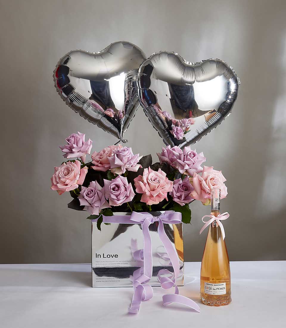 Valentine's Wine With Oceansong and Faiht Roses Bouquet With Silver Serenade Heart Balloons In The Silver Paper Bag With a Purple Bow.