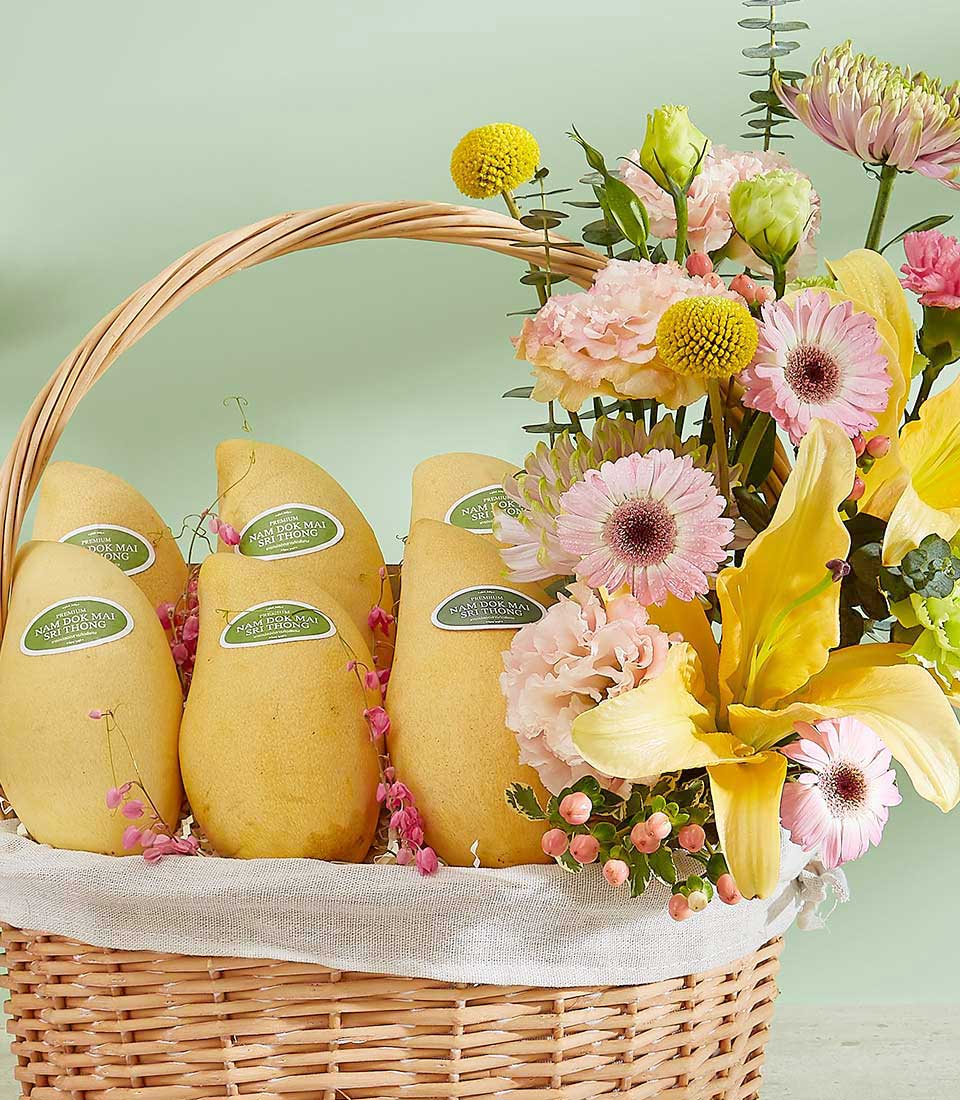 A wicker basket filled with ripe yellow mangoes on the left, each labeled 