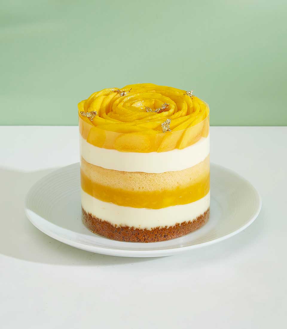 Indulge in the tropical bliss of our Swirled Mango Mini Layer Cake. Layers of moist cake infused with fresh mango flavors, topped with a swirl of creamy frosting.