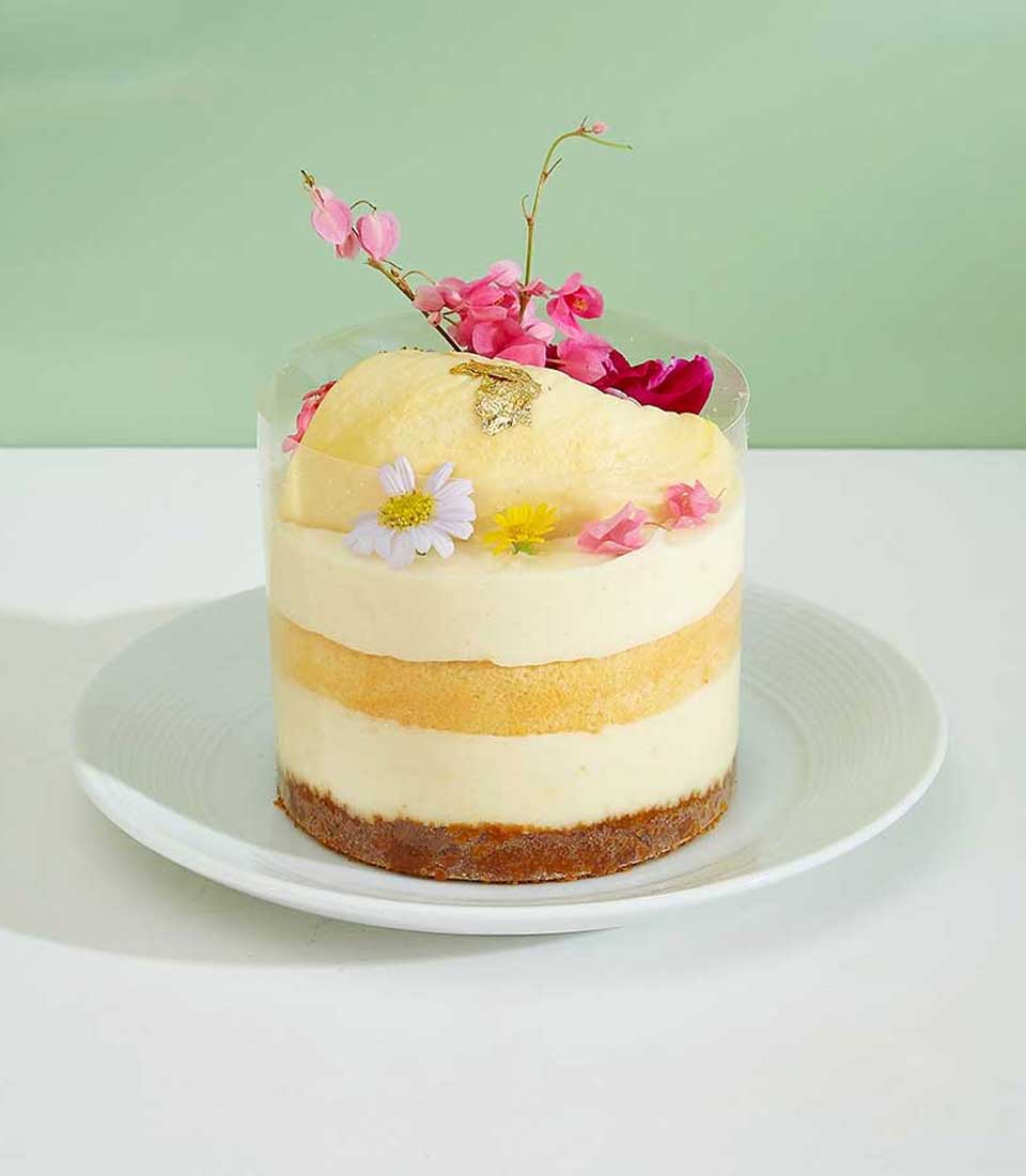 Mini durian topped layer cake featuring layers of fluffy cake filled with luscious durian cream, topped with fresh durian slices, a delightful treat for durian lovers.