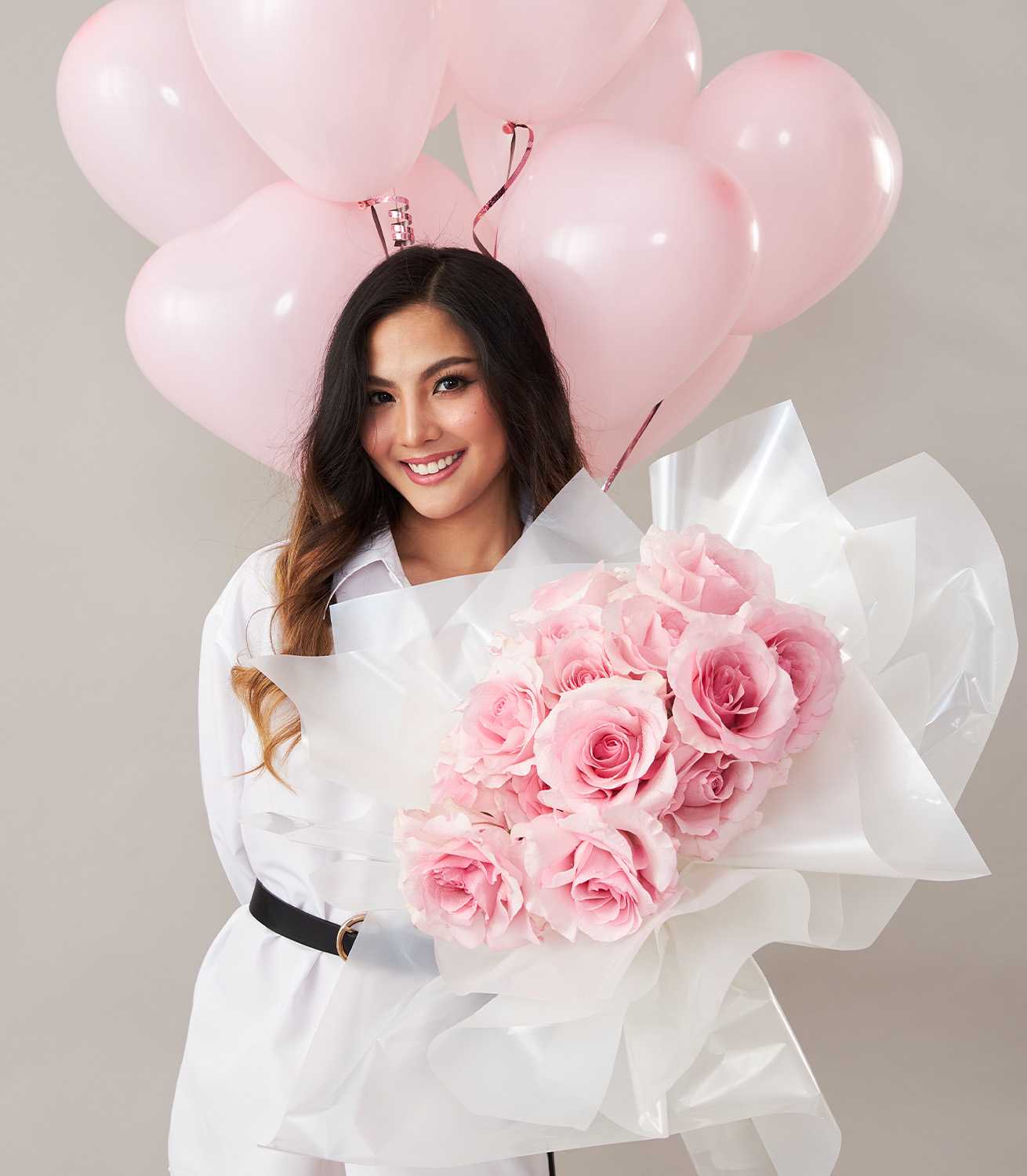 Soft Pink Floral Bouquet With Heart Balloons Fiesta Gift SetSmiling woman holding a pink rose bouquet and pink heart-shaped balloons