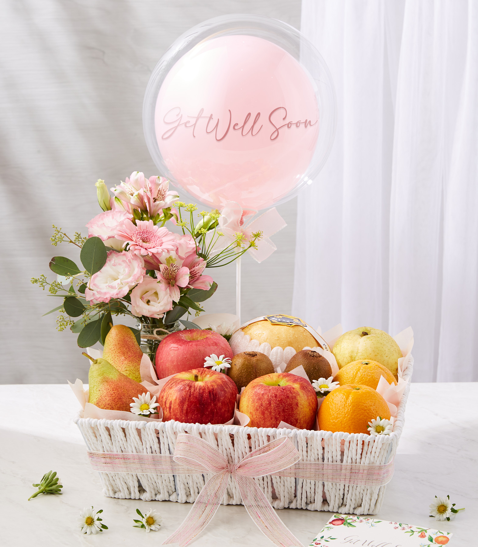 Fresh Fruits And Pink Get Well Soon Balloon In The White Basket With A Small Pink Flowers Vase
