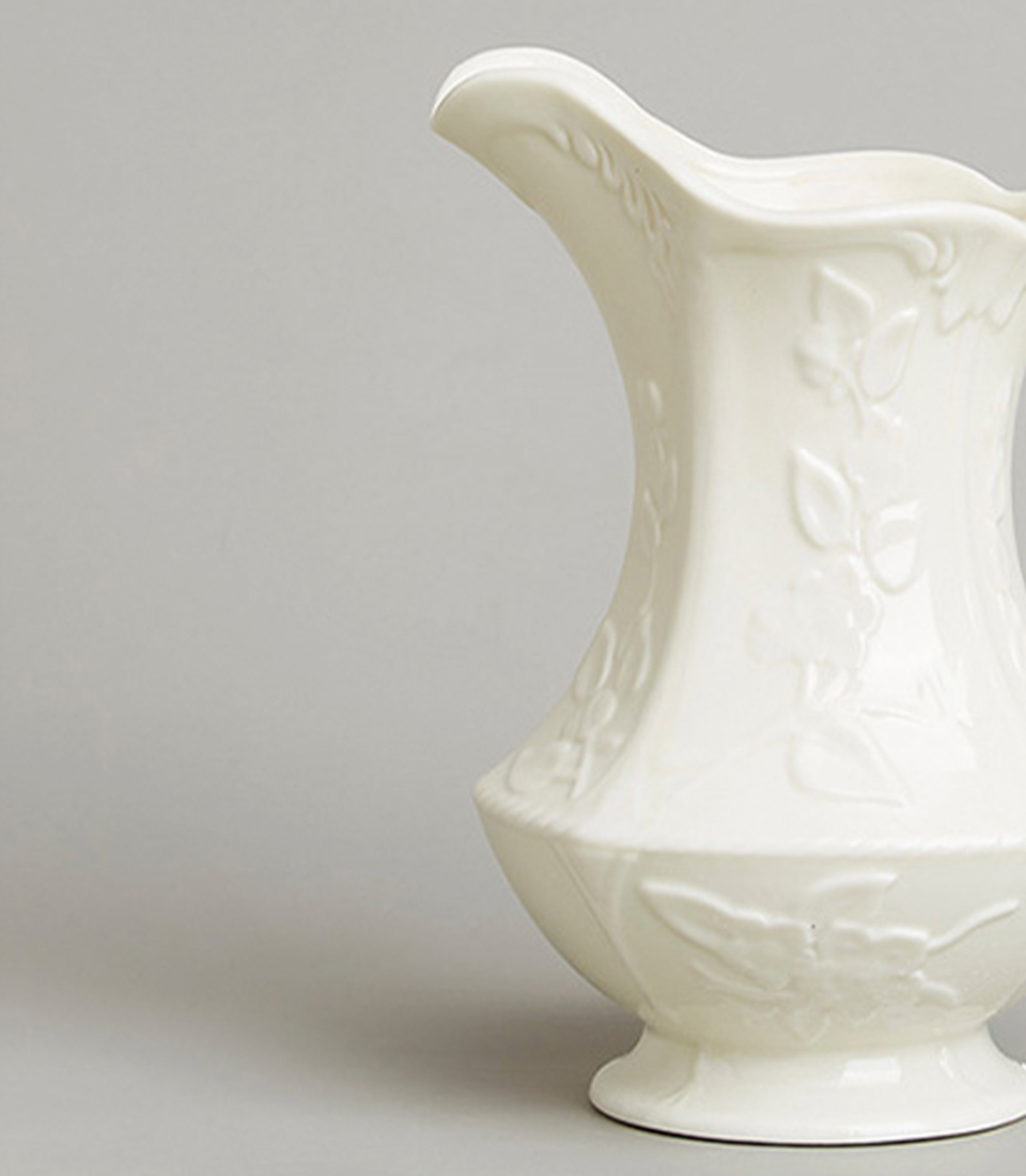 Close-up view of White Ceramic Pitcher with Floral Embossed Design.