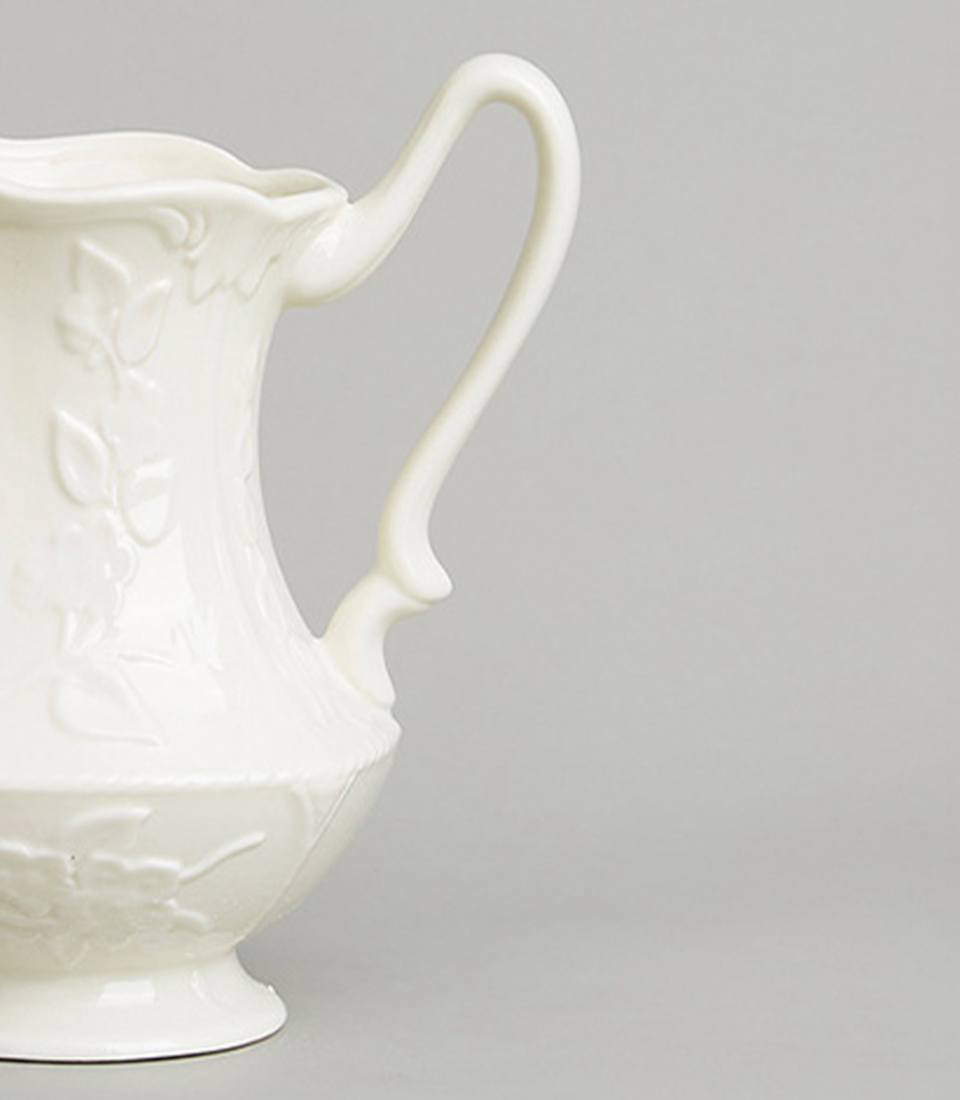 Close-up view of White Ceramic Pitcher with Floral Embossed Design.